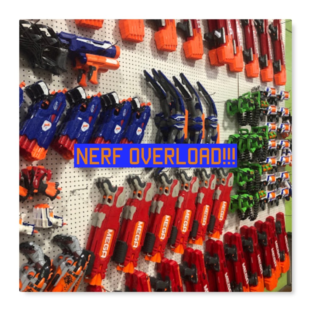 nerf blasters hanging on white pegboard attached to wall the nerf guns are covering the whole image from left to right